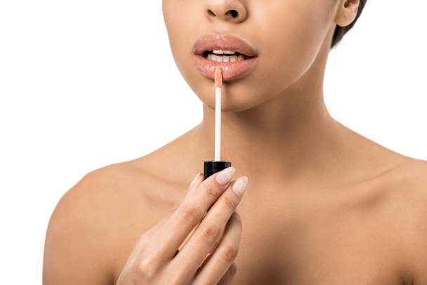 cropped shot of naked young african american woman applying lip gloss isolated on white  - Foto, immagini