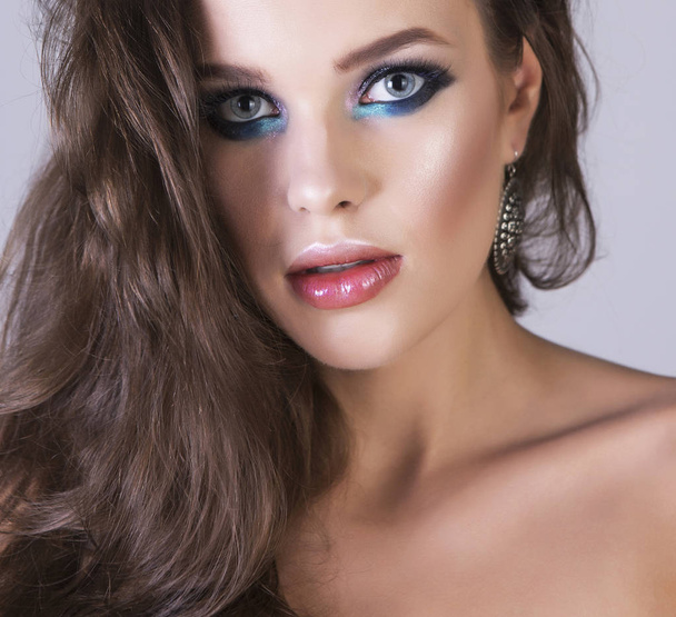 Sexy and elegant portrait of a young brunette girl with professional shiny makeup. - Zdjęcie, obraz