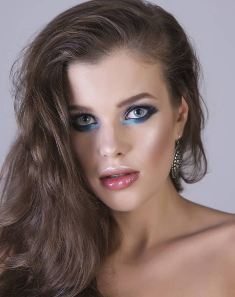 Sexy portrait of a young brunette girl with artistic shiny makeup. Vertical studio shot. - Fotó, kép