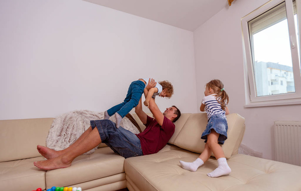 crianças menino e menina brincando com o homem sorridente juntos em casa
 - Foto, Imagem