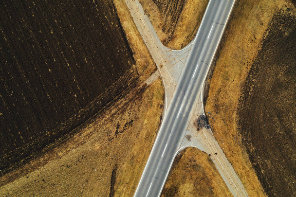 Aerial view of empty road through countryside landscape, abstract top view from drone pov in autumn afternoon - Fotografie, Obrázek