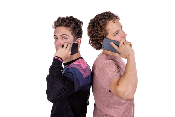 Портрет двух счастливых молодых людей, использующих мобильные телефоны
 - Фото, изображение