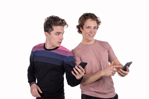 Portrait of a two happy young men using mobile phones - Фото, изображение