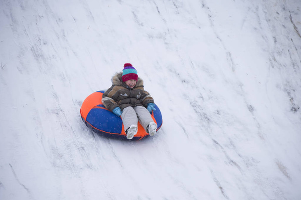 Sleeën. gelukkig kind op vakantie. Winter pret en spelletjes. Kleine jongen genieten van een slee tocht. Kinderen spelen buiten in de sneeuw. Kinder slee in de Alpen bergen in de winter - Foto, afbeelding