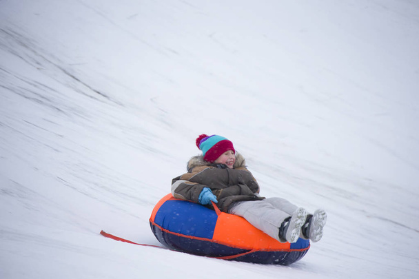 Sleeën. gelukkig kind op vakantie. Winter pret en spelletjes. Kleine jongen genieten van een slee tocht. Kinderen spelen buiten in de sneeuw. Kinder slee in de Alpen bergen in de winter - Foto, afbeelding