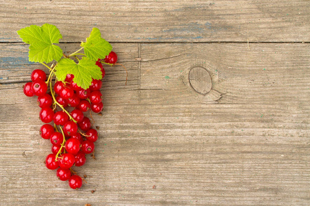 bunch of red currants on old wooden Board . Top View and copy space - 写真・画像