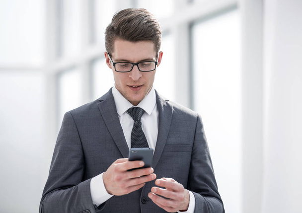 young businessman reading SMS on his smartphone - Φωτογραφία, εικόνα