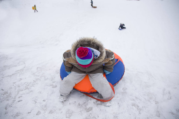 バカンス Sledding.Happy 子。冬の楽しさとゲーム。そりに乗るを楽しんでいる小さな男の子。雪の中で子供を促します。冬のアルプスの山々 で子供そり - 写真・画像