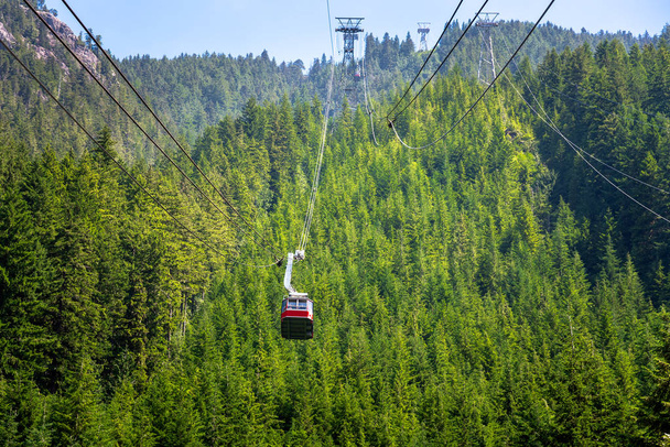 Vista de un teleférico sobre una ladera boscosa Llevando a los turistas a la cima de una montaña. Grouse Mountain, Vancouver, BC, Canadá
. - Foto, imagen