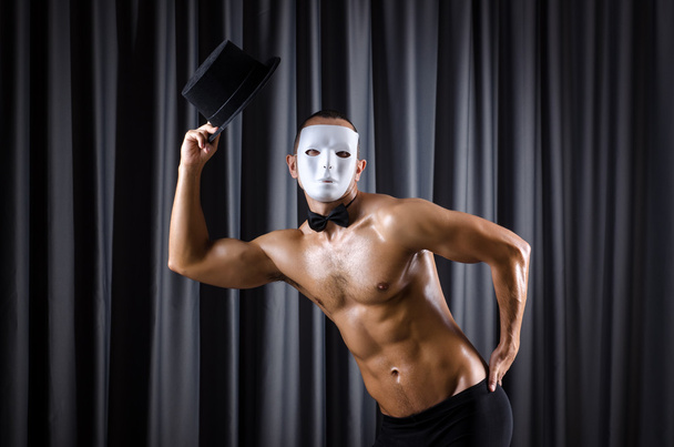 Muscular actor with mask against curtain - 写真・画像