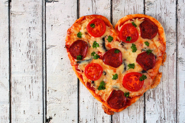Heart shaped pizza for Valentines Day on a white wood background. Top view. - Foto, Imagem
