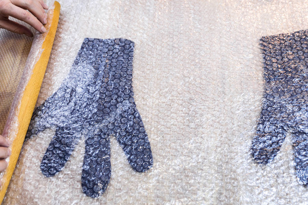 Workshop Ruční výroby fleece rukavice z modré Merino ovčí vlny pomocí procesu mokré plstění - řemeslník rolích plstěné rukavice s dřevěnou váleček na valchování - Fotografie, Obrázek
