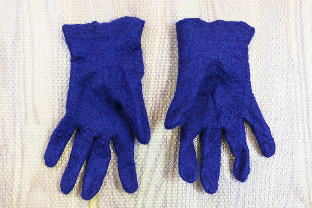 laboratorio di fabbricazione a mano di guanti in pile di lana di pecora Merino blu con processo di infeltrimento umido - guanti in feltro umido finiti su tappetino
 - Foto, immagini