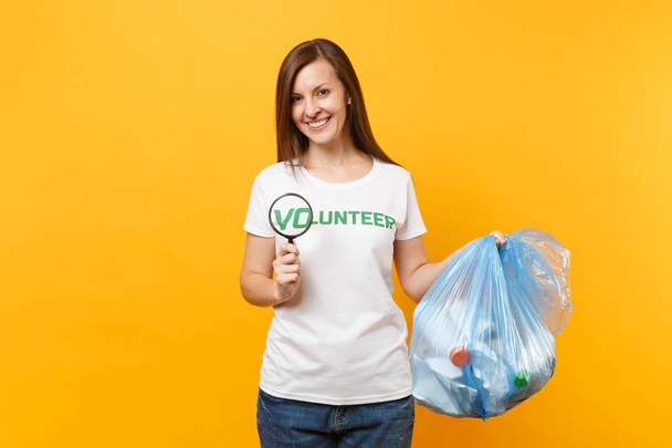 T シャツのボランティア、ゴミ箱に女性はバッグに分離された黄色の背景です。自主的な無料アシスタンスのヘルプ、チャリティーの恵み。環境汚染問題。自然こみ環境保護の概念を停止します。 - 写真・画像