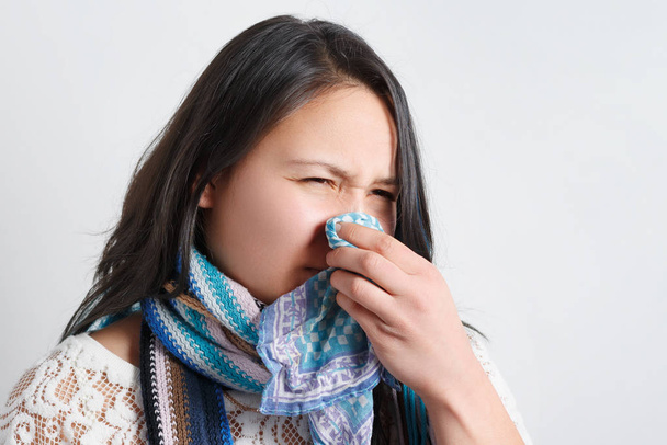Woman with a cold blowing her runny nose with tissue. Portrait of Asian beautiful girl get sick sneezing from flu. Healthcare and medical concept. - Fotografie, Obrázek