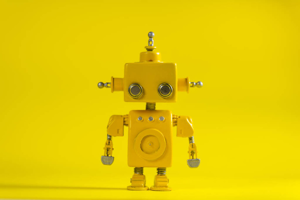 Cute, yellow, handmade robot on a yellow background. - Фото, зображення