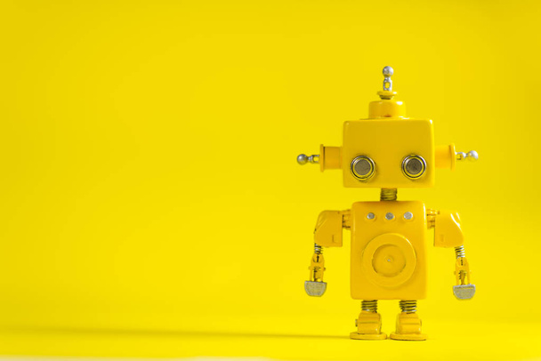 Cute, yellow, handmade robot on a yellow background. - Fotoğraf, Görsel