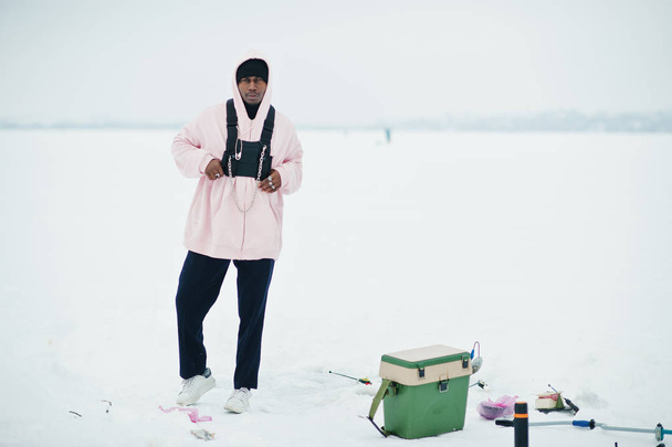 African american fisherman on frozen sea. Winter fishing. - Photo, Image