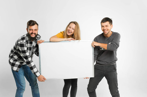 Young people holding white board - Фото, зображення