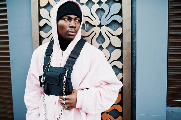 Stylish urban style african american man in pink hoodie posed. Afro rapper guy. - Zdjęcie, obraz