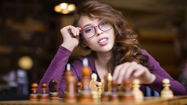 Mujer jugando ajedrez interior y posición de pensamiento, encontrar movimiento ganador, estrategia
 - Foto, imagen
