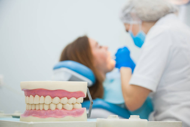 Ослабленное, размытое изображение дантиста с пациентом в офисе клиники. Стоматолог делает лечение зубов в больнице
. - Фото, изображение