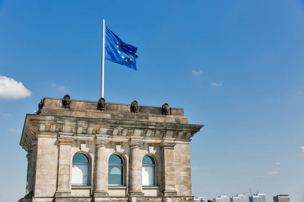 Vista da vicino della famosa torre del Reichstag e della bandiera dell'Unione europea con paesaggio urbano di Berlino. Distretto di Mitte, Germania
. - Foto, immagini