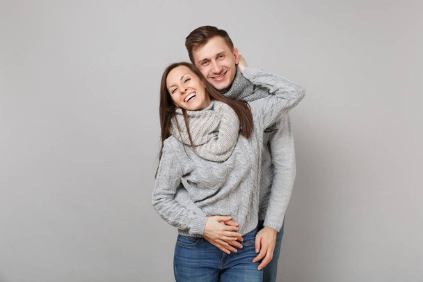 若いかわいいカップル灰色セーター、マフラー一緒に灰色の壁の背景、スタジオ ポートレートに分離で女の子男。健康的なライフ スタイル、病気病気病気治療、寒い季節の概念。コピー スペースをモックアップします。 - 写真・画像