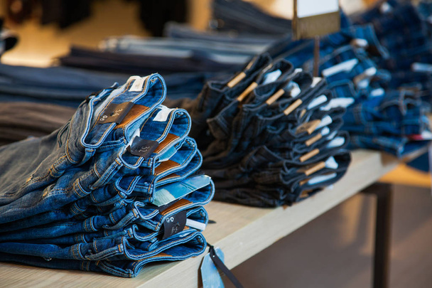 Shopping sale mall concept, denim jeans clothes on store shelves - Foto, Bild