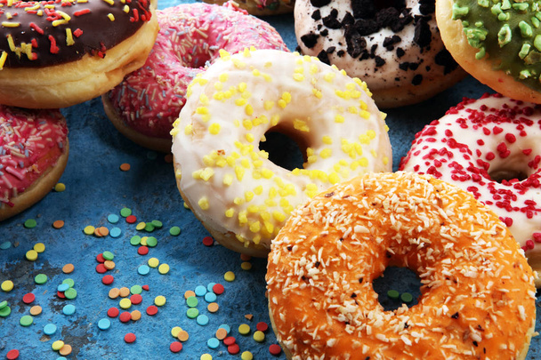 assorted donuts with chocolate frosted, pink glazed and sprinkles donuts. carnival concept. - Photo, Image