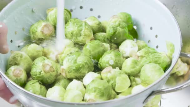 Male hands washing fresh brussels sprouts in colander, close up view - Video, Çekim