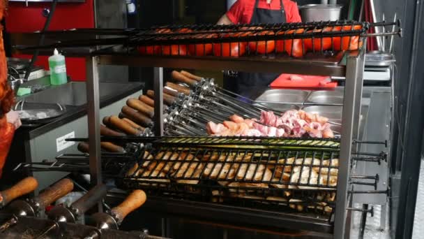 Cooking kebabs or barbecue in restaurant or cafe over charcoal. Preparing barbecue with delicious grilled meat on skewers is prepared on coals in kitchen of restaurant. Turn over meat on grill. - Footage, Video