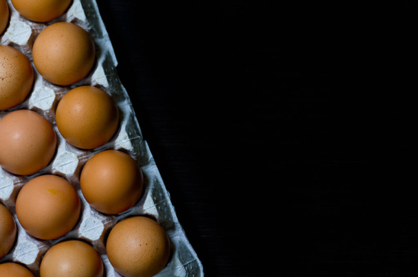 Eier Eierschachtel Kopierraum Lebensmittelschachtel dunkel Holz Board Draufsicht oben. - Foto, Bild