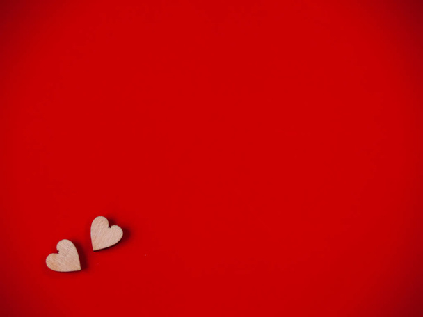 Aşk iki küçük ahşap kalp kırmızı bir arka plan üzerinde kavramı - Fotoğraf, Görsel