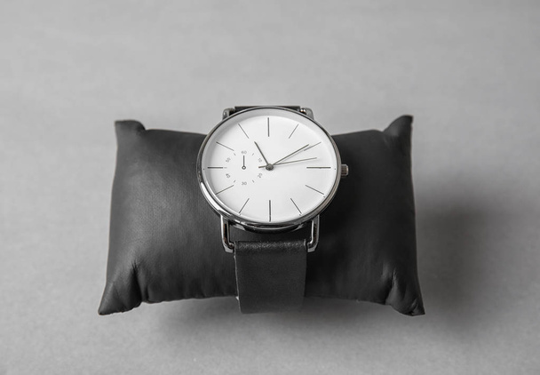 Small decorative pillow with stylish wrist watch on gray background. Fashion accessory - Foto, Imagen