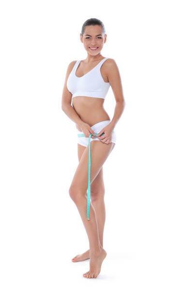 Štíhlá žena, měření její boky na bílém pozadí. Ztráta hmotnosti - Fotografie, Obrázek