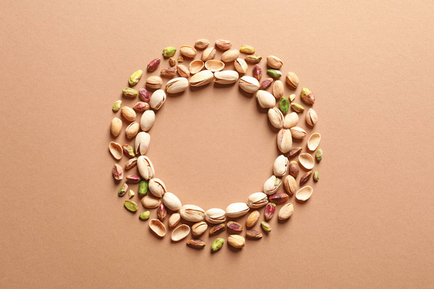 Round frame made of organic pistachio nuts, flat lay. Space for text - Photo, Image