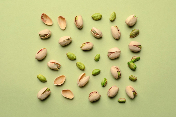 Composition with organic pistachio nuts on color background, flat lay - Foto, immagini