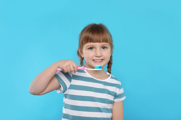 Little girl with toothbrush on color background. Teeth care - Foto, Bild