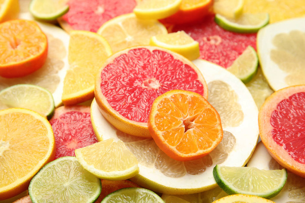 Slices of different citrus fruits as background - Foto, Imagen