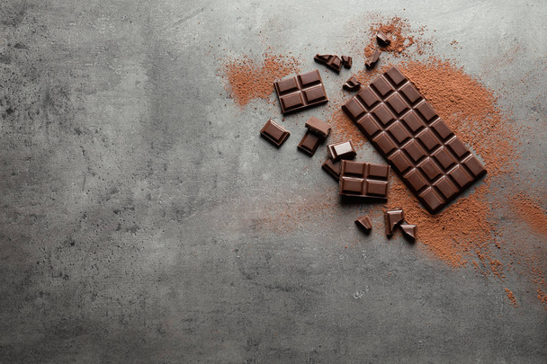 Flat lay composition with tasty chocolate on grey background. Space for text - Photo, Image