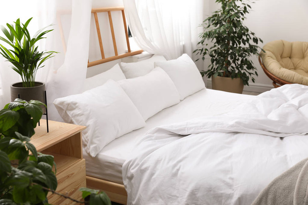 Comfortable bed with soft pillows in room interior - Foto, imagen