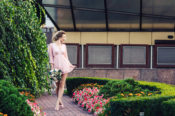 сексуальная молодая девушка в коротком розовом платье позирует ходьба в парке
. - Фото, изображение