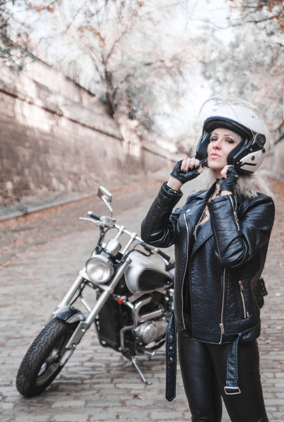 Fiatal nő pózol egy szabadtéri motorkerékpár. - Fotó, kép