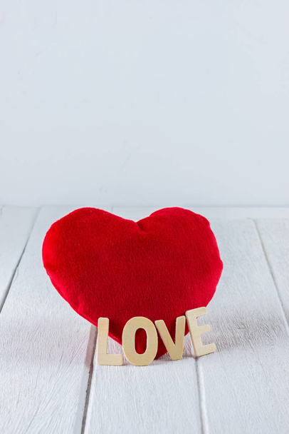Fondo de San Valentín con forma de corazón rojo y letras de madera palabra "AMOR" en la mesa de madera blanca y espacio de copia para su gráfico
. - Foto, Imagen