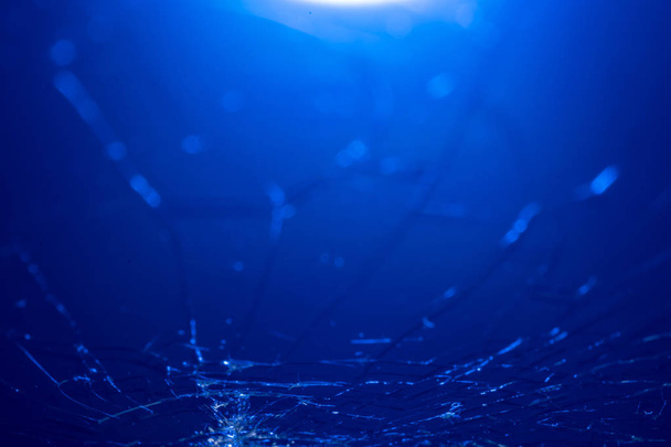 Broken smartphone screen, cracks and shattered glass under various eels - Photo, image