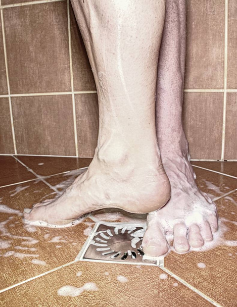 Para dorosłych gry prysznicem, Nagie stopy na wiejskich uprawiali podłogi. Romantyczny motyw. - Zdjęcie, obraz