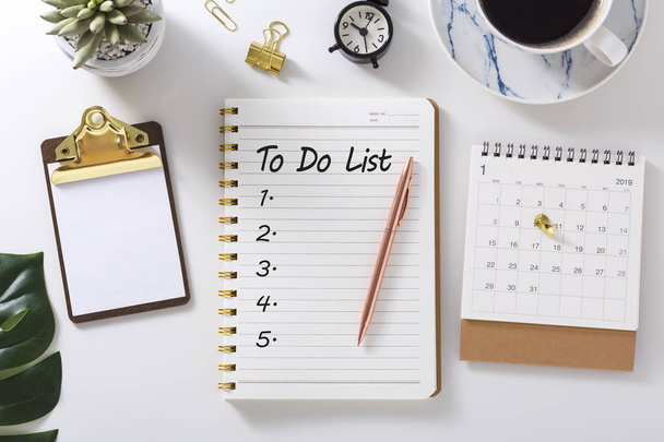 Lista de tareas en cuaderno con calendario y reloj en escritorio blanco
 - Foto, imagen