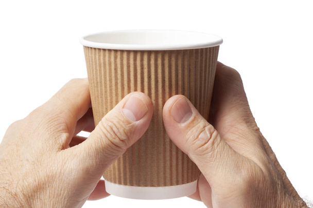 Carton cup of coffee in two human hands on white. - Photo, Image