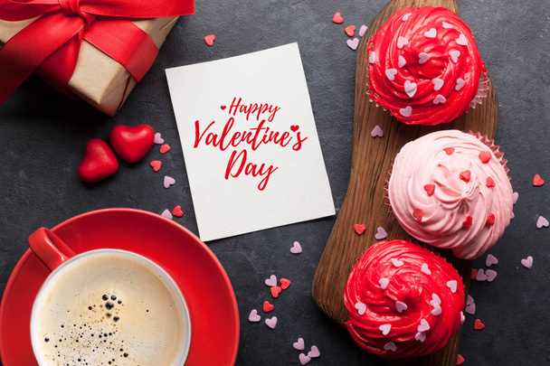 Valentine's day greeting card with delicious sweet cupcakes on stone background - Фото, зображення